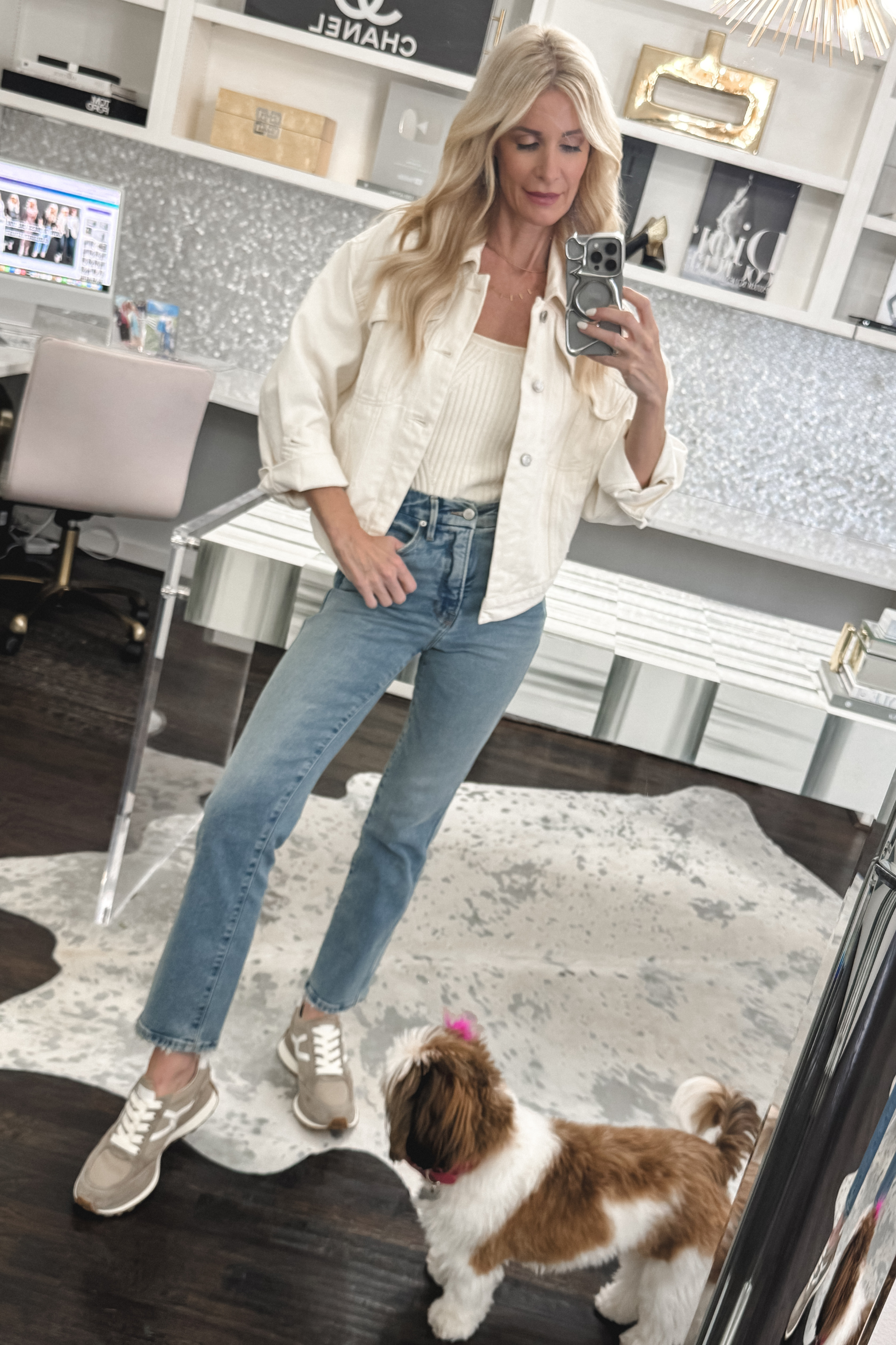 Over 40 fashion stylist wearing a pair of ankle length jeans with a white denim jacket.