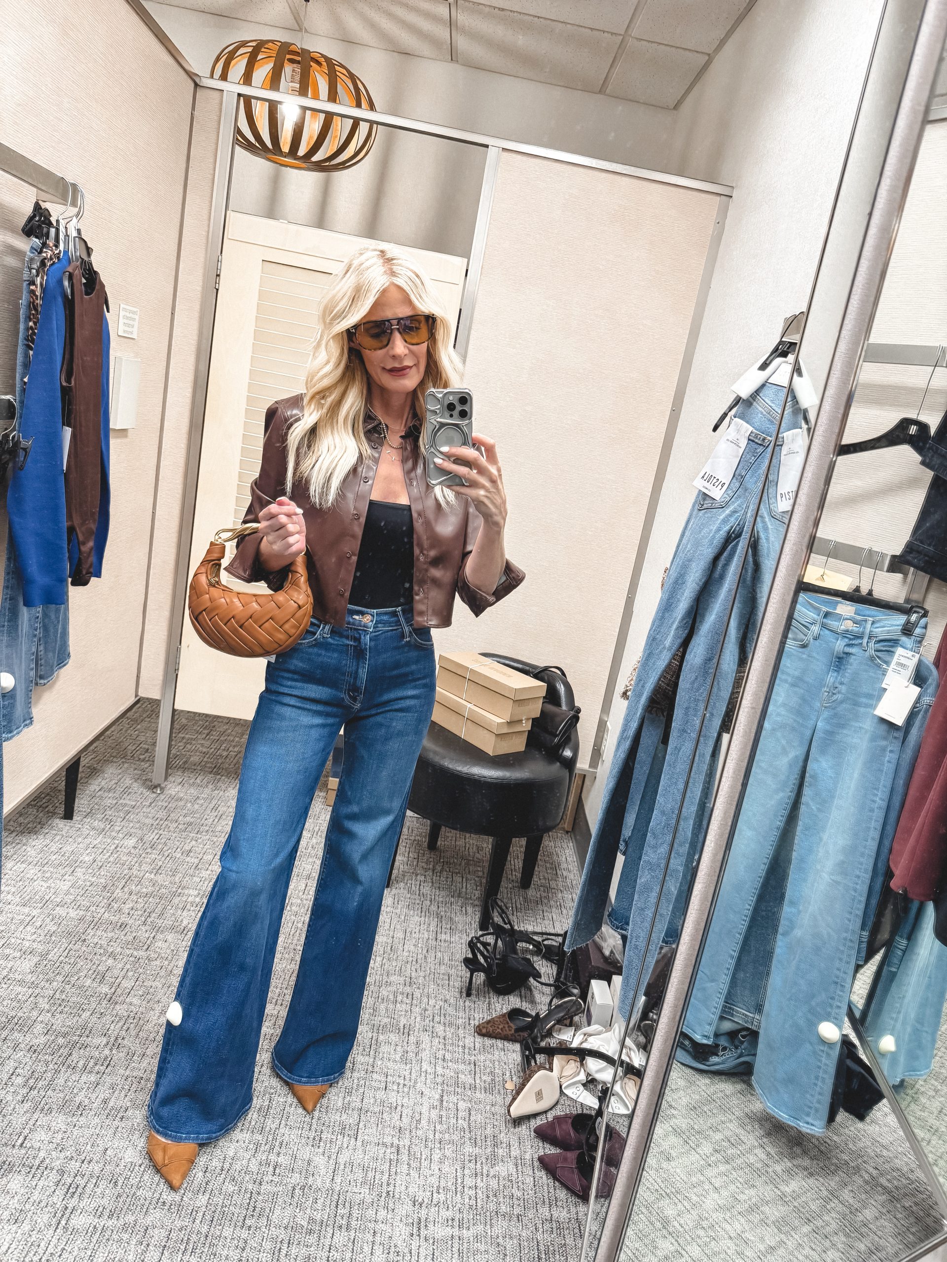 Dallas fashion blogger for women over 40 wearing a faux leather shirt with flare jeans and suede heels.