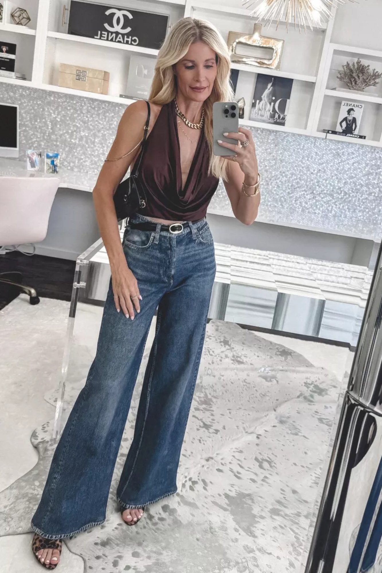 Over 40 fashion stylist wearing a halter top instead of a turtleneck with sweat pant jeans.