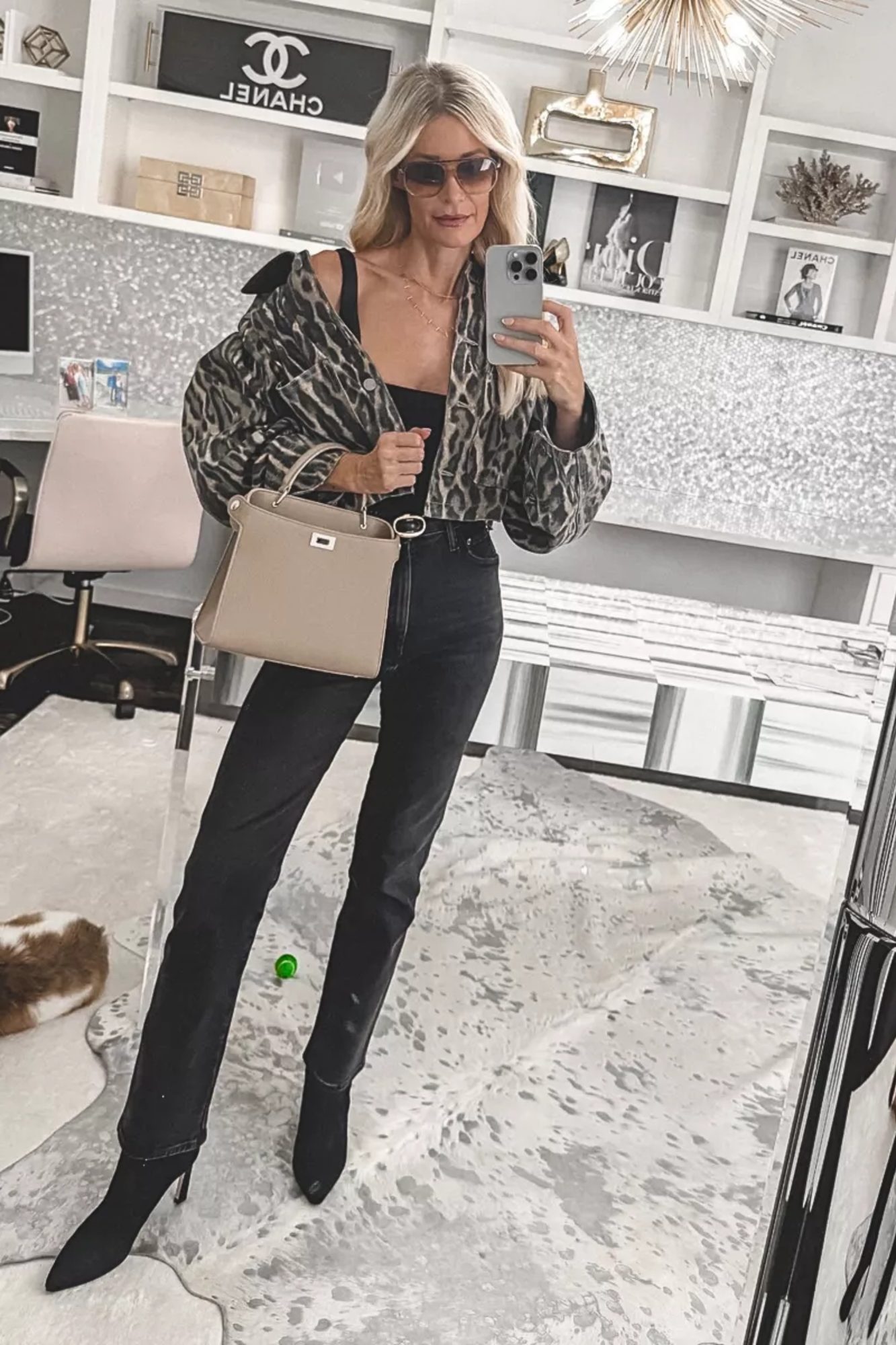 Over 40 fashion blogger wearing a leopard jacket with black jeans and sock booties that are the perfect alternative to one of 5 Fall fashion mistakes over 40.