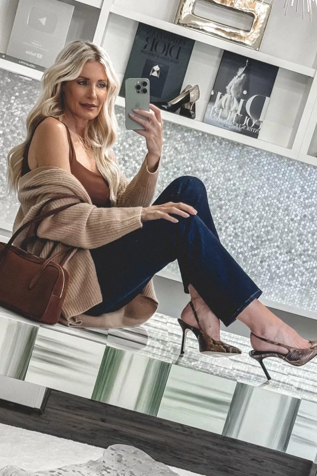 Dallas fashion stylist wearing darkwash denim with a camel cardigan and snake print heels.
