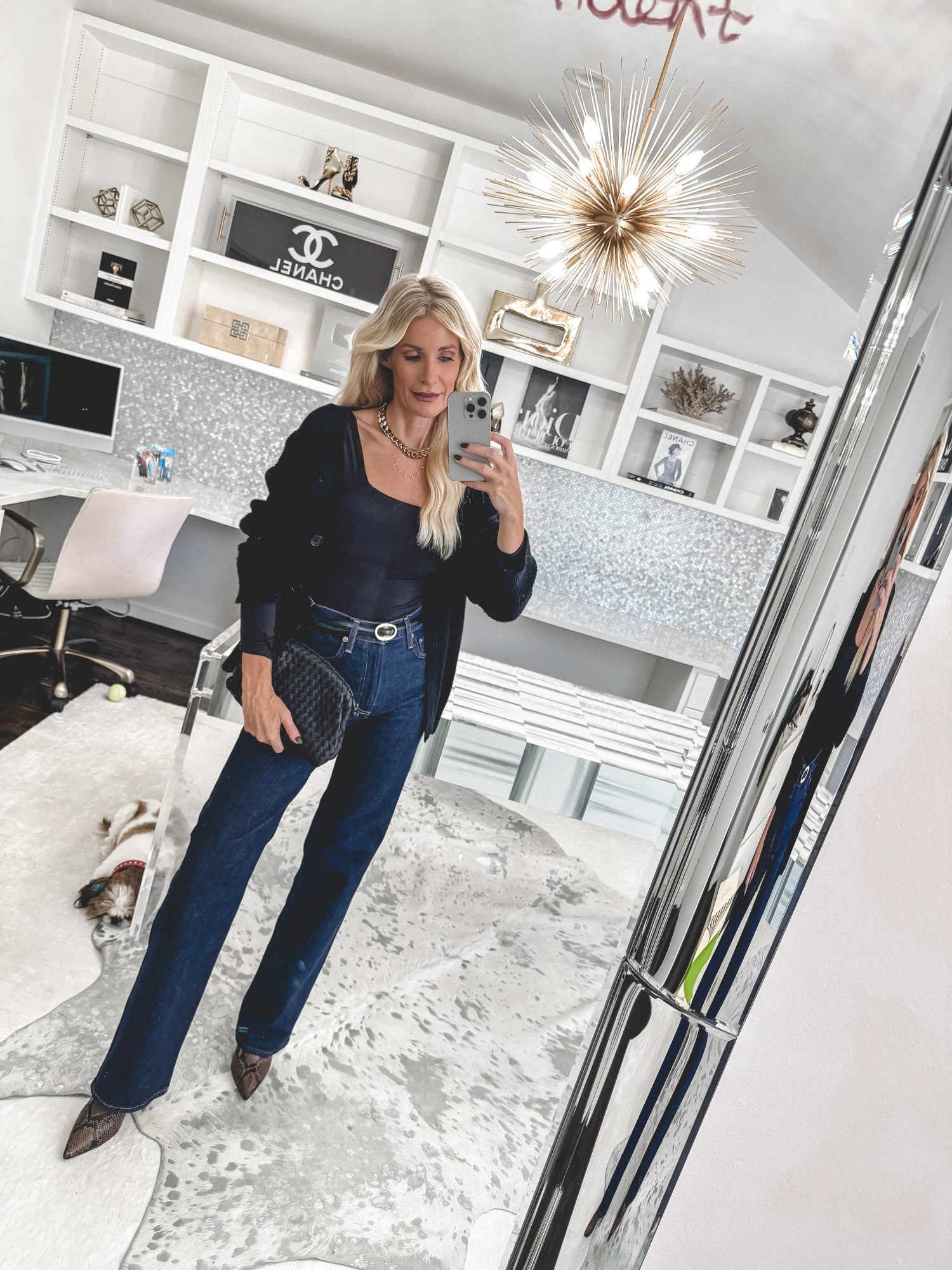 Close up of a over 40 stylist from Dallas wearing high-waisted straight-leg jeans in a dark wash and trending snake skin booties.