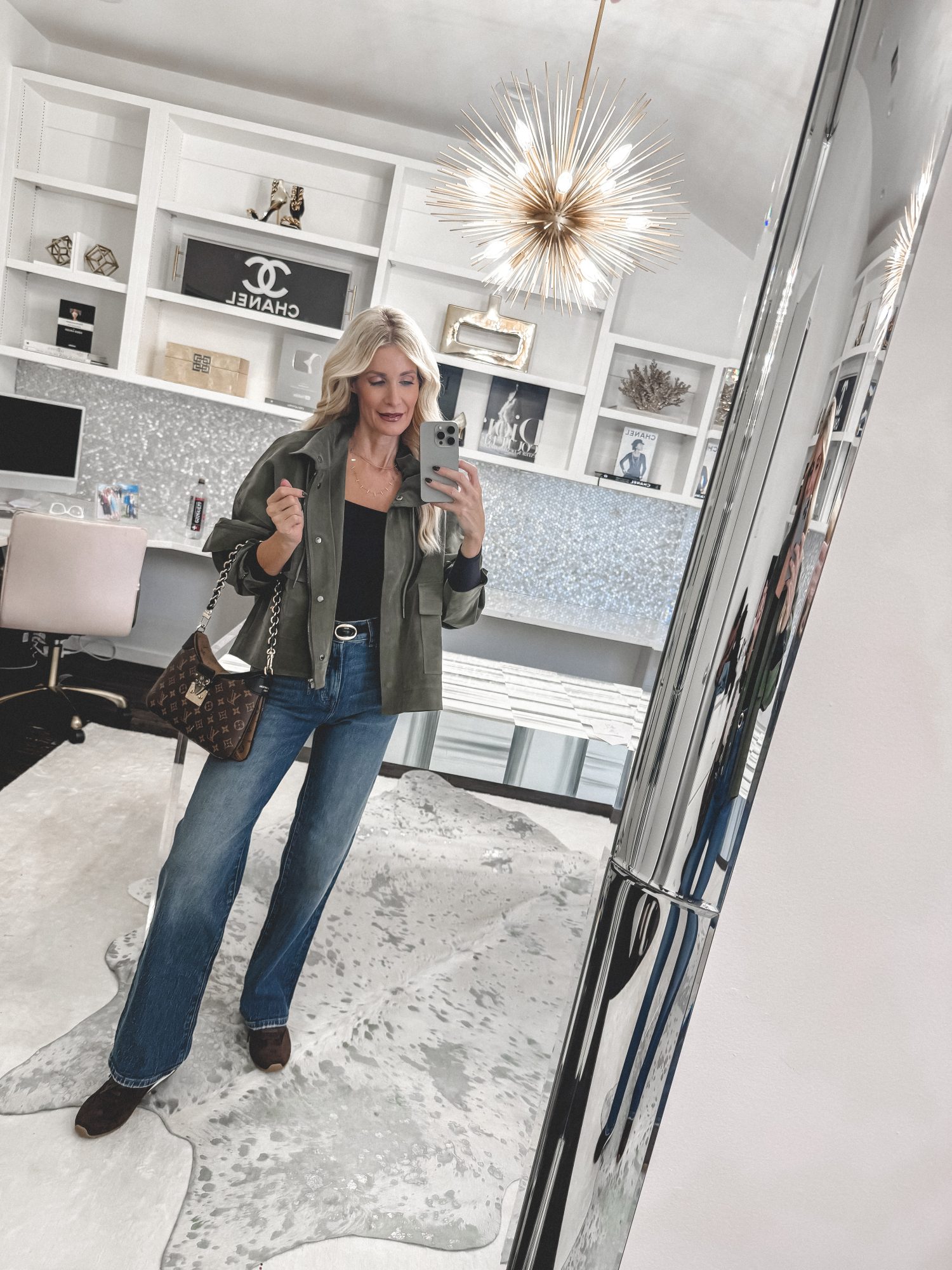 Over 40 fashion influencer wearing a green army jacket wide leg jeans and brown sneakers as part of the ultimate Fall Capsule Wardrobe 2025.