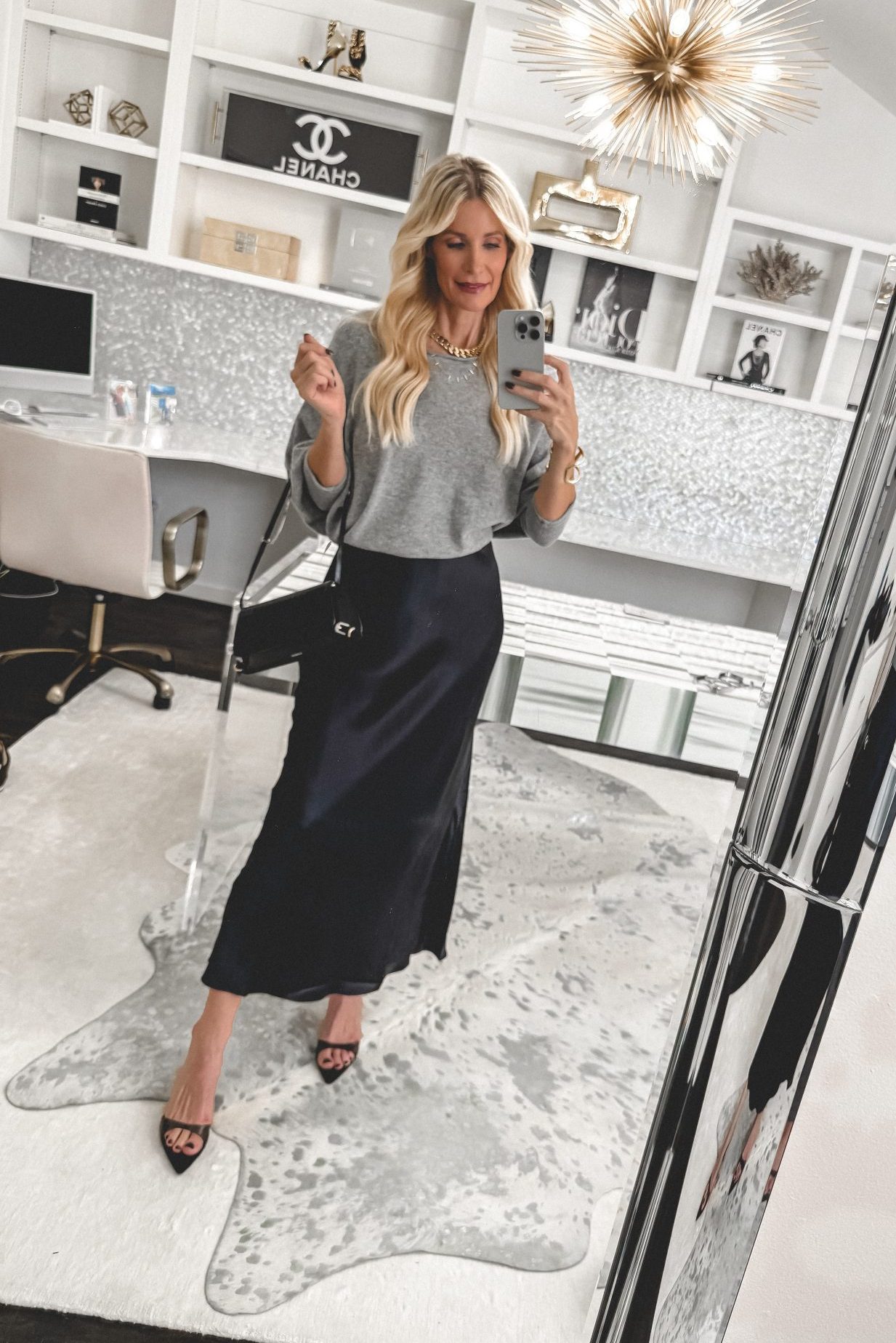 Over 40 stylist wearing a cashmere sweater in a cool hack that makes it cropped with a silk maxi dress.