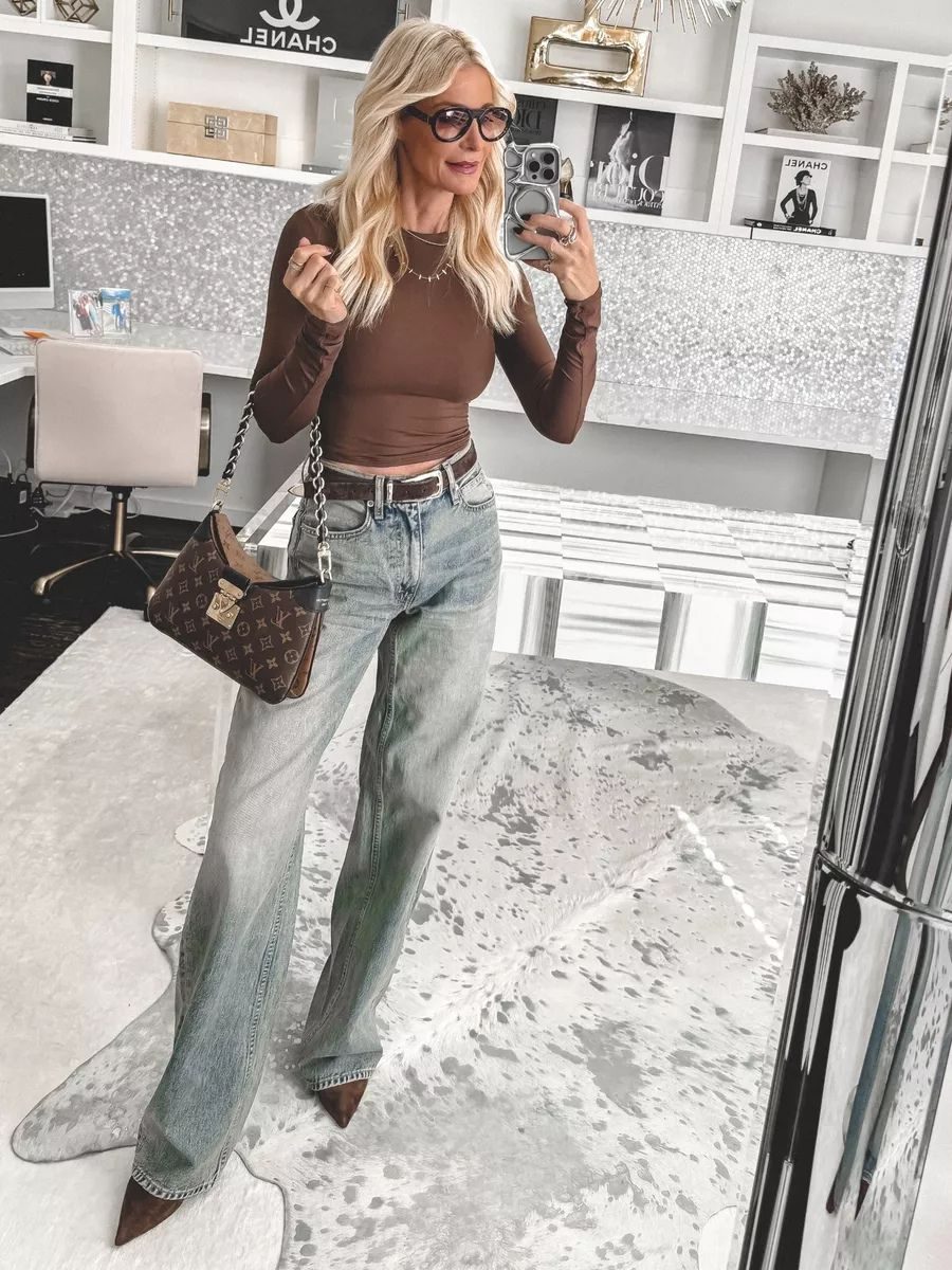 Dallas fashion blogger showcasing the hottest 2026 denim trends but wearing puddled wide leg jeans with a fitted brown long sleeve.