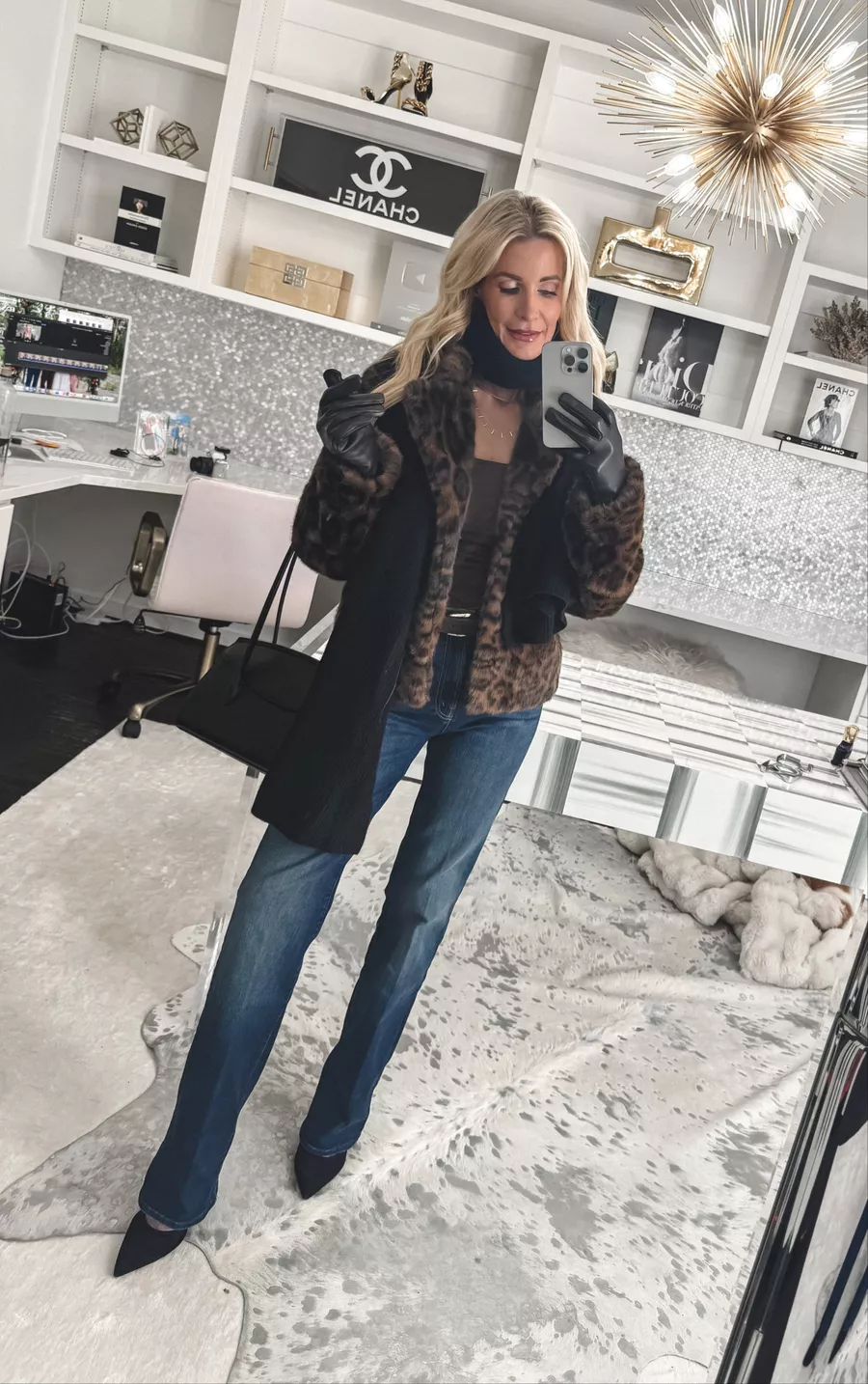 Over 40 fashion influencer wearing a cashmere scarf, cashmere lined gloves and a black leather handbag as examples of the top last-minute gifts under $100.