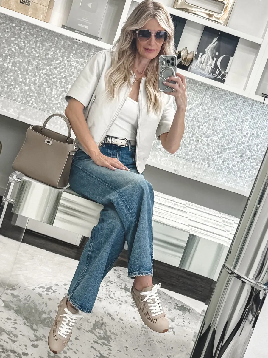 Dallas Fashion blogger showcasing a pair of trending mesh sneakers with straight leg jeans and a short sleeve bomber jacket as the final one of 5 Designer Dupes for Women Over 40.