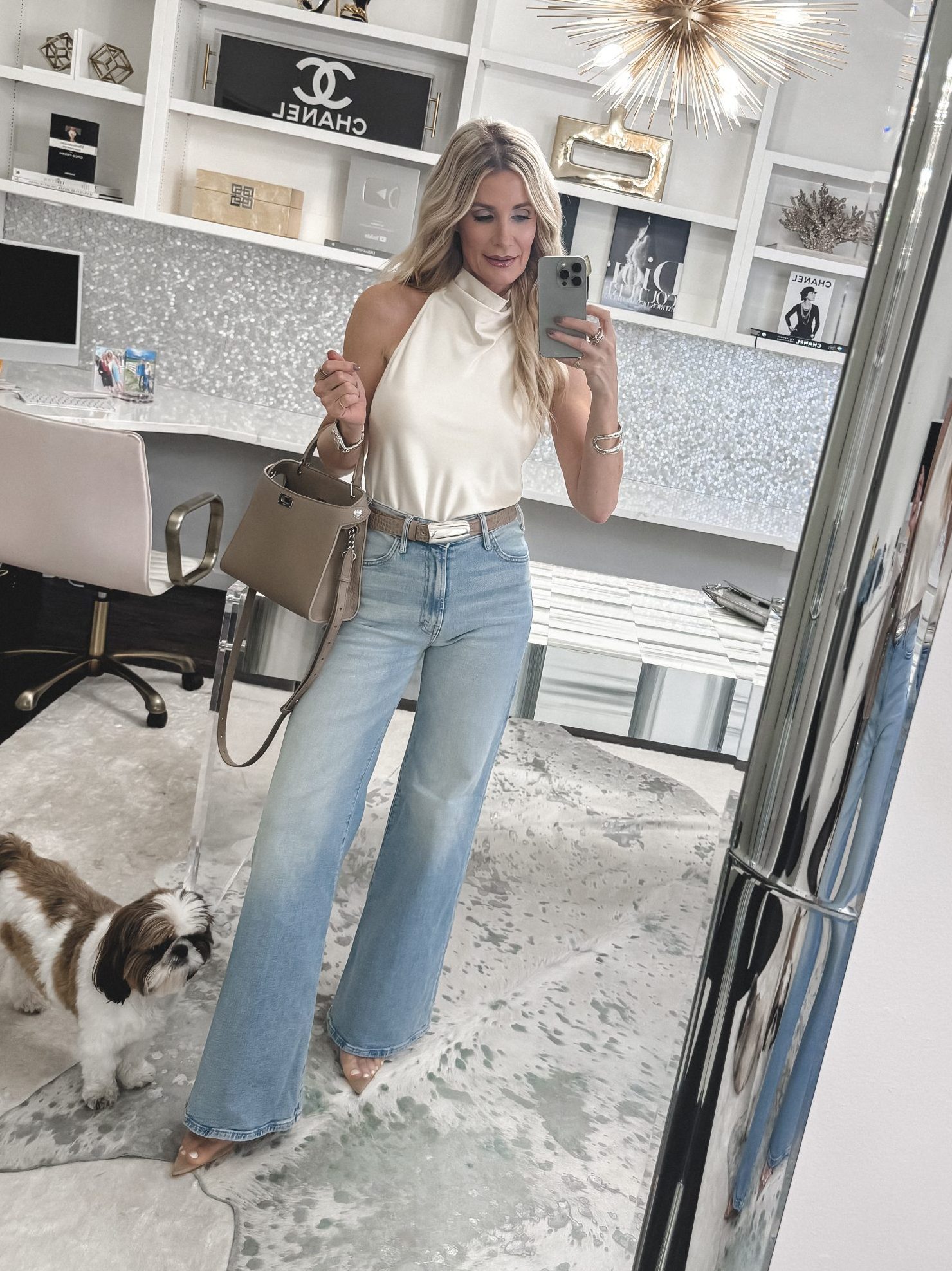 Over 40 fashion stylist wearing wide leg jeans with mesh pumps and a ivory silk halter top.