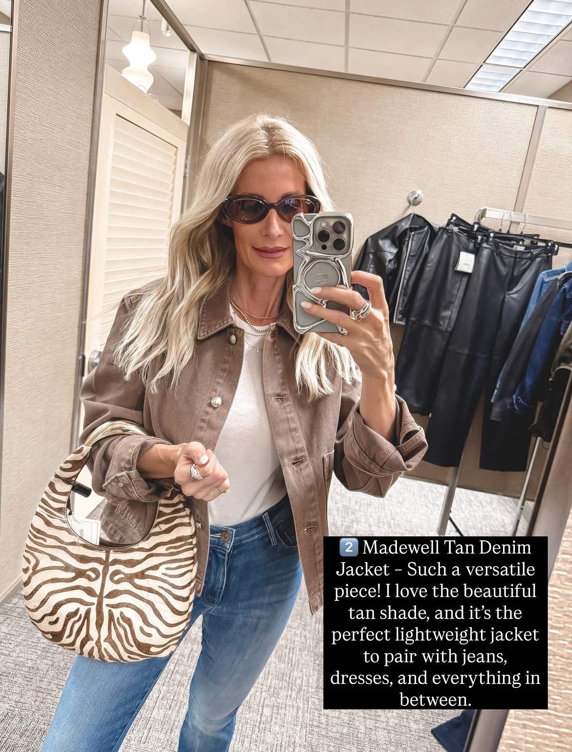 Dallas fashion influencer wearing a light tan denim jacket with a white tee, jeans and a zebra handbag.