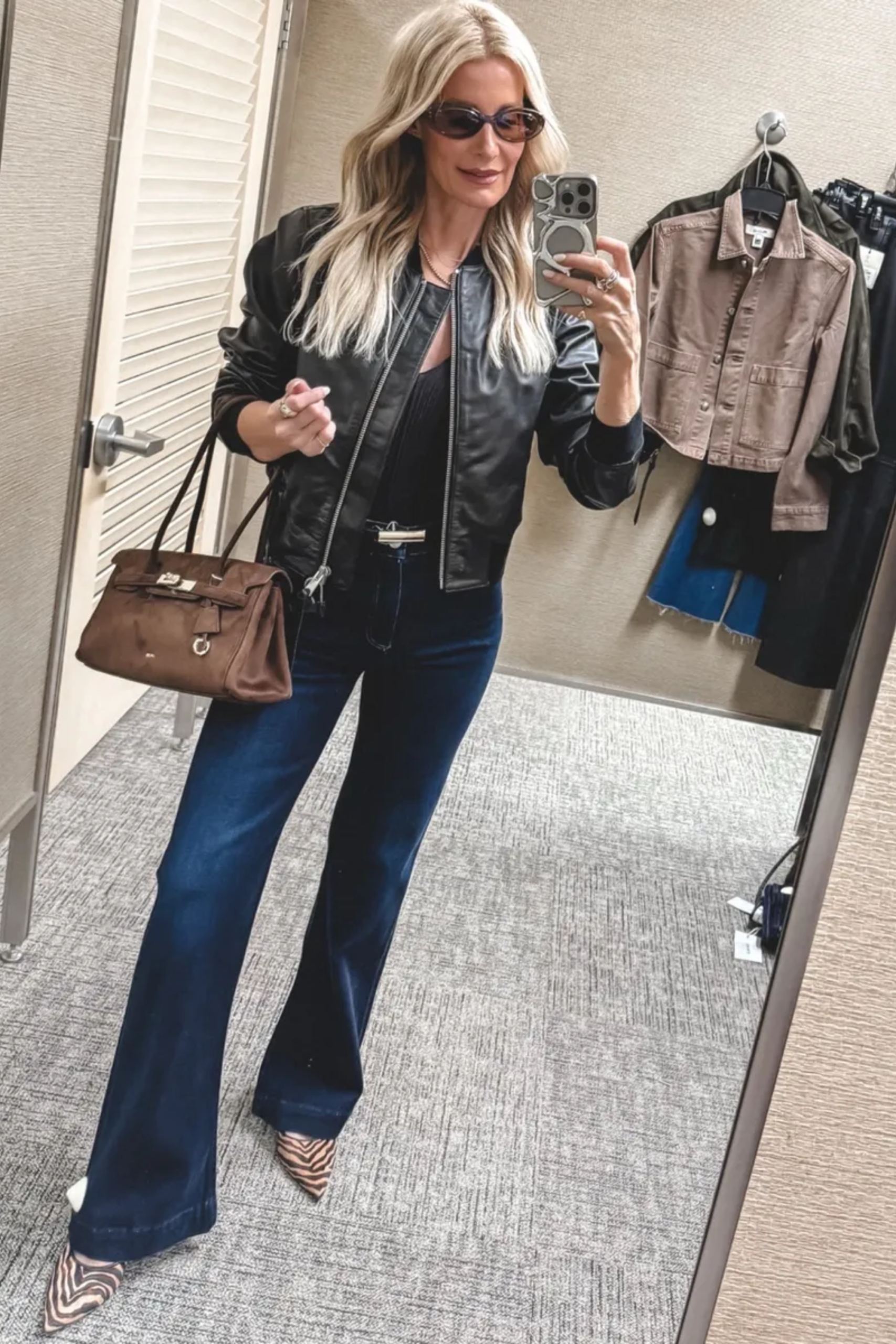 Dallas fashion influencer for women over 40 wearing a black leather jackets with a brown suede handbag and zebra heels as one of 10 Nordstrom Anniversary Sale Outfits.