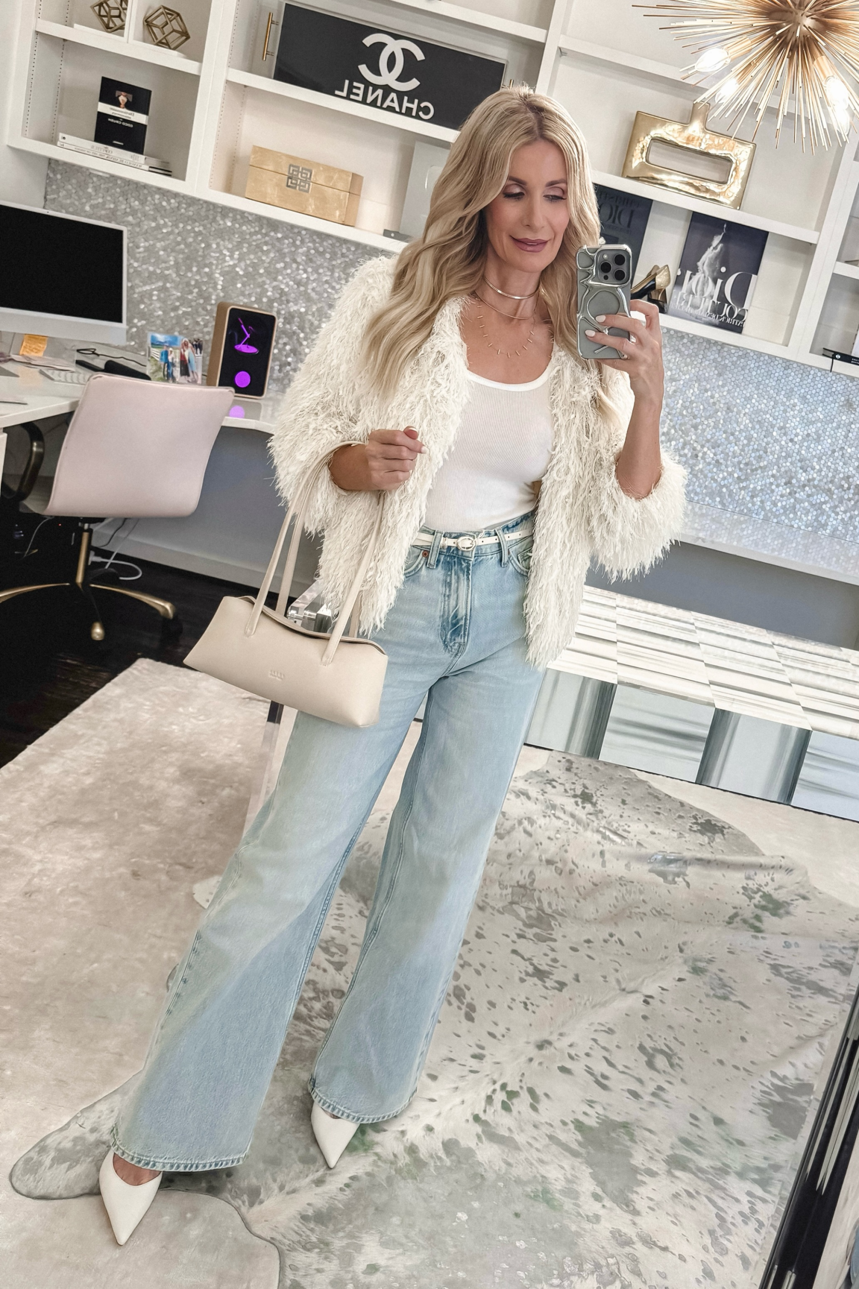 Fashion stylist for women over 40 wearing a fur fringe jacket with light wash jeans and ivory slingbacks.