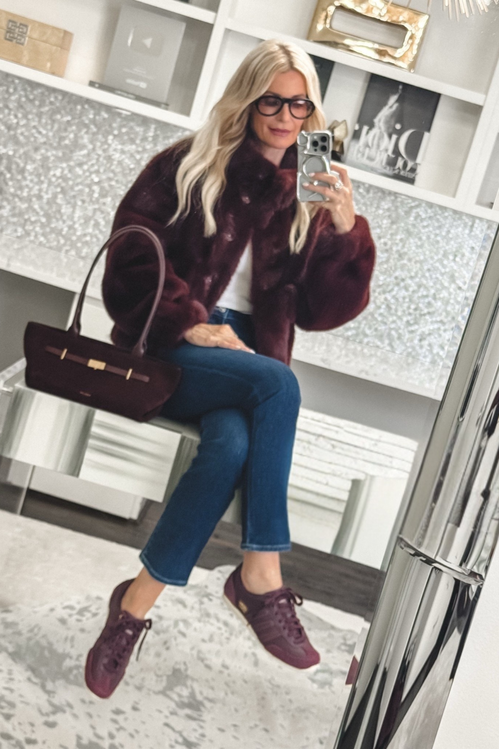 Dallas fashion stylist for women over 40 wearing a faux fur bomber jacket with straight leg jeans and burgundy sneakers.
