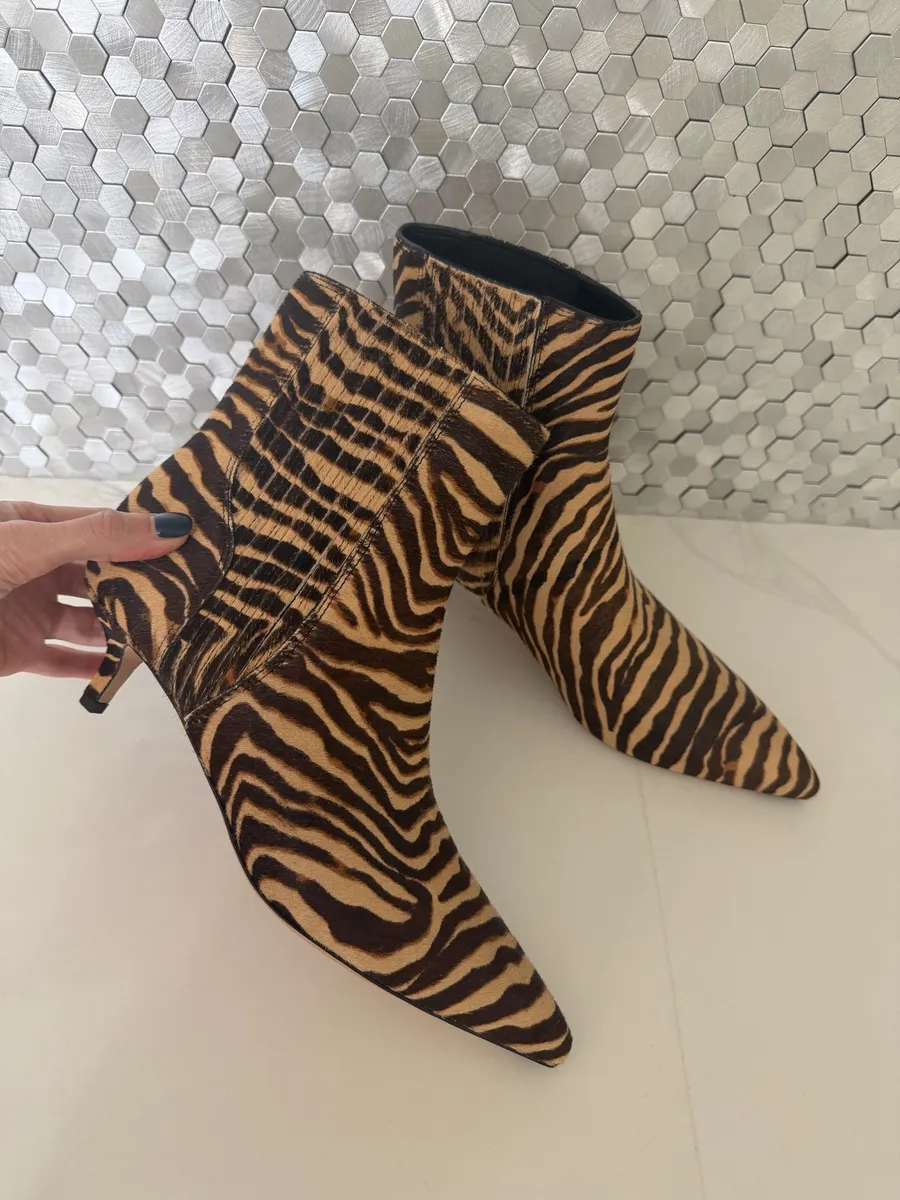 A pair of zebra print booties that is one of the hottest 2026 fall boot trends.
